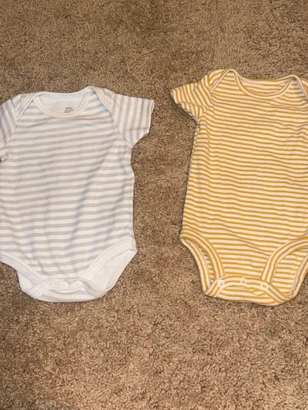 white and yellow striped baby onesies